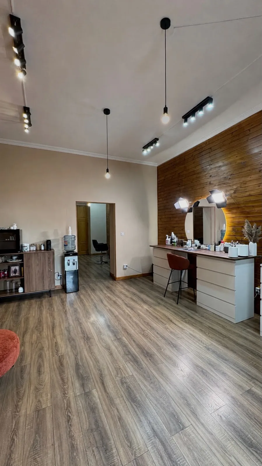 Camera principală a studioului, cu masa de machiaj, oglinda rotundă cu lumini și peretele de lemn
